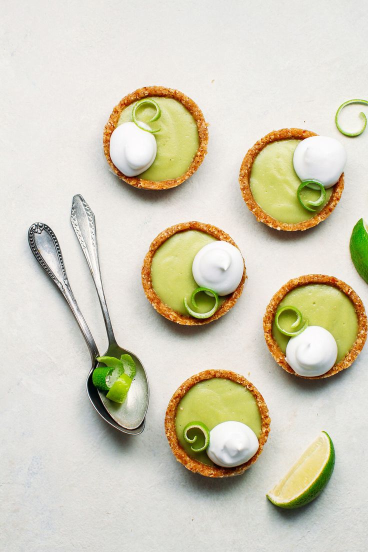 small desserts with green and white toppings on a table next to lime wedges