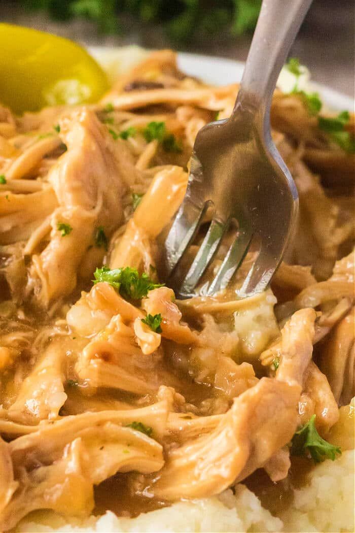 a fork is stuck into some chicken and rice