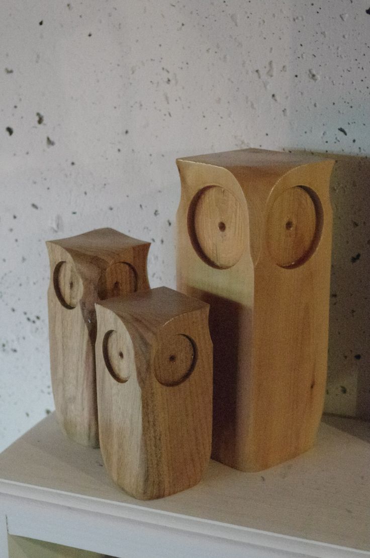 three wooden owls sitting on top of a shelf