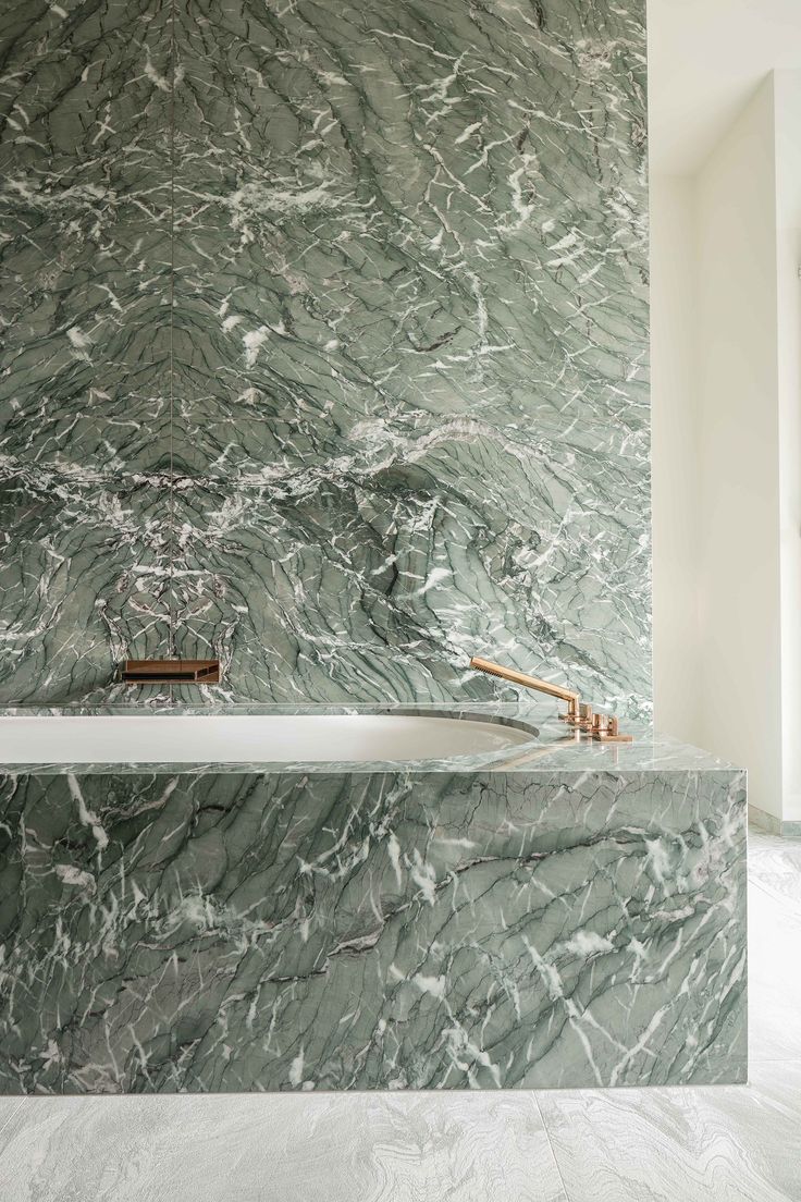 a bathroom with marble walls and flooring that looks like it has been painted green