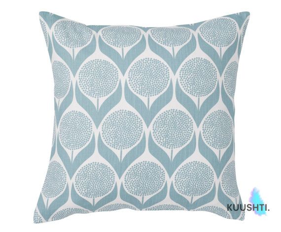 a blue and white pillow with large leaves on it