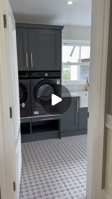 a washer and dryer are in the middle of a room with grey cabinets