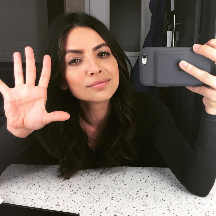 a woman is holding up her phone to take a selfie with the camera in front of her