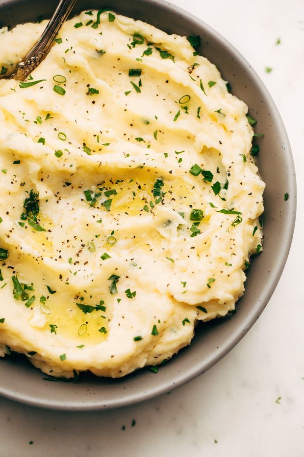 a bowl filled with mashed potatoes topped with parsley