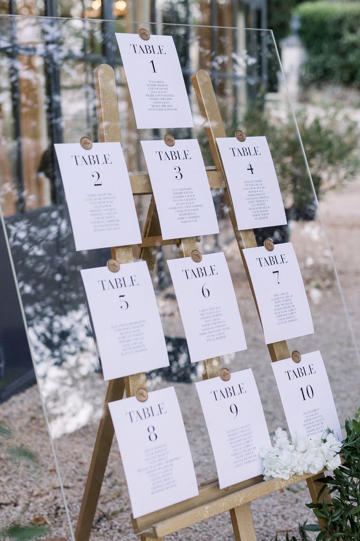 a wooden easel with seating cards on it