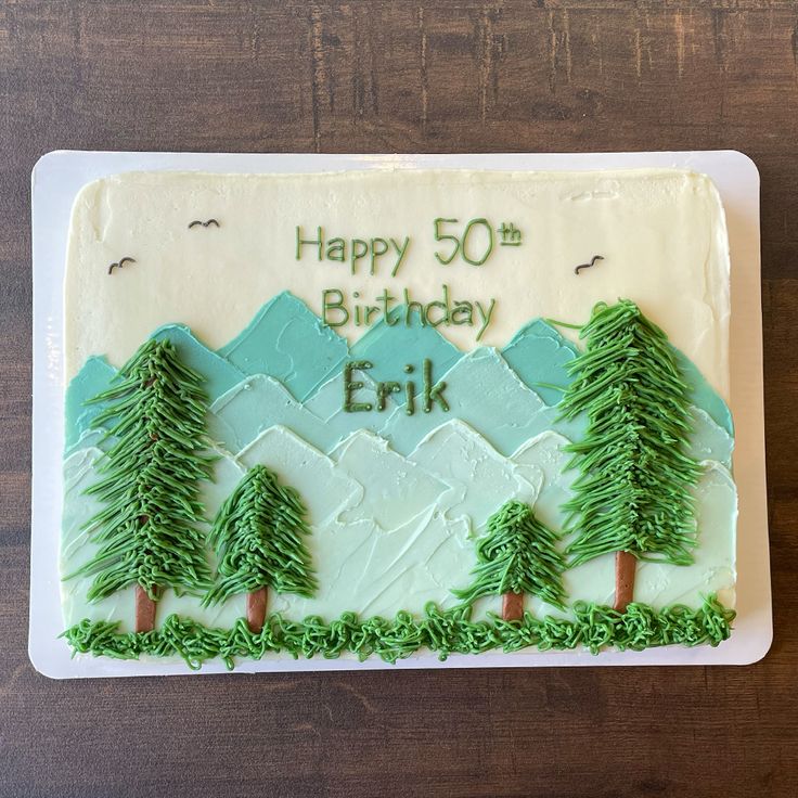 a birthday cake with green frosting and trees on it