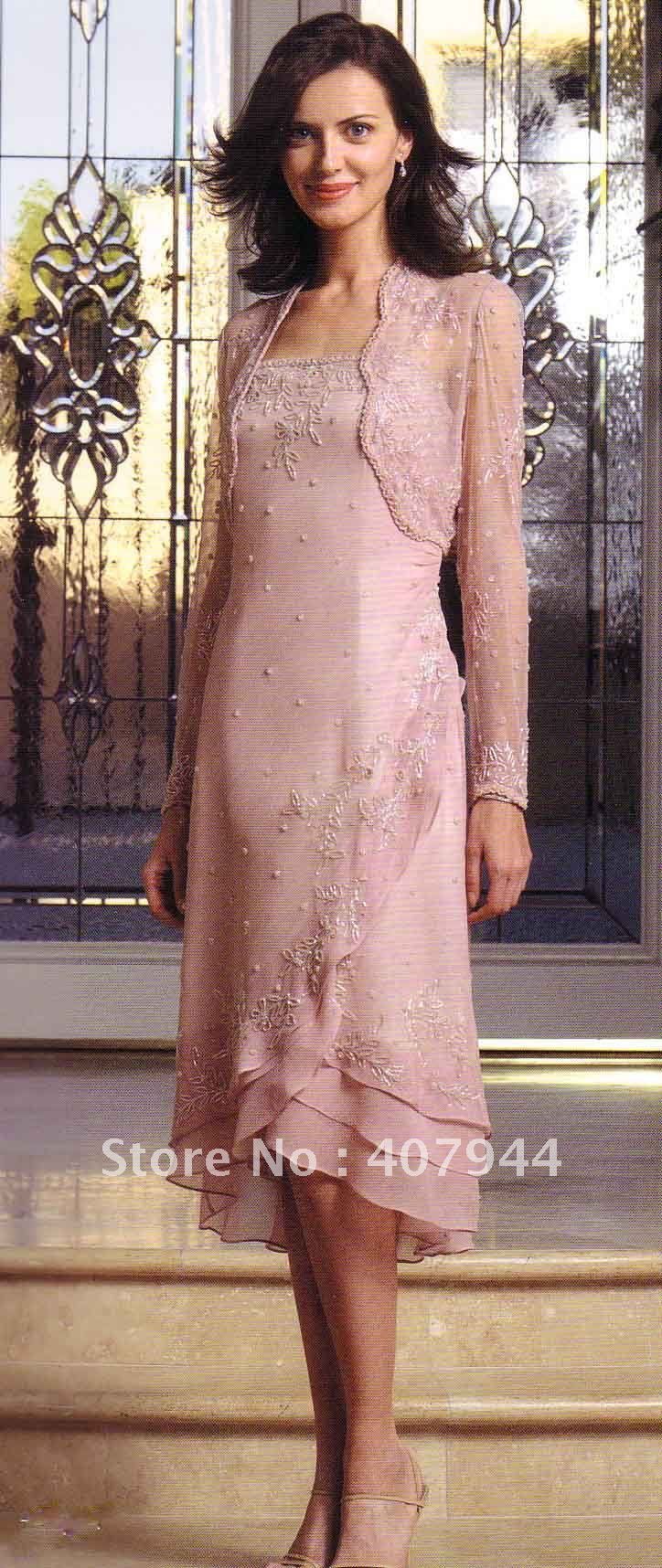 a woman standing in front of a window wearing a pink dress and matching heels with her hand on her hip