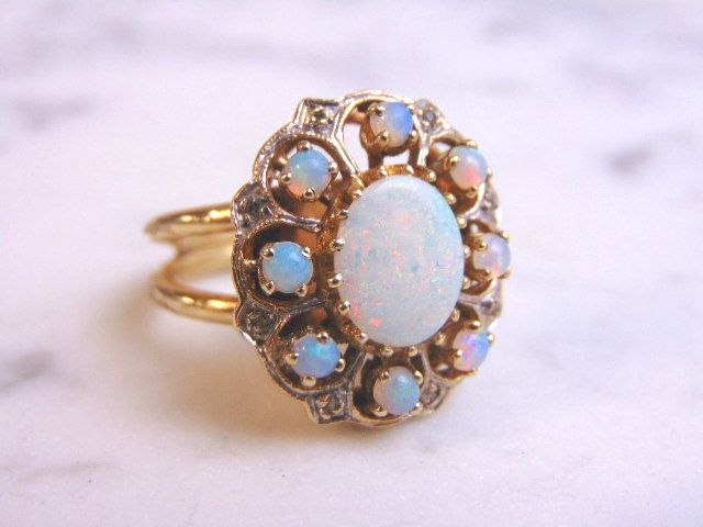 FOR SALE IS THIS UNIQUE WOMEN'S VINTAGE ESTATE 14K GOLD OPAL & DIAMOND RING. THE RING IS A SIZE 6.25 AND WEIGHS 10.0g. NOT SURE IF THE OPALS ARE REAL OR MANMADE. THE CENTER STONE IS ABOUT 2.0cts. THE DIAMONDS ARE REAL AND THERE ARE ABOUT .08cts. RING IS NOT MARKED BUT IT HAS BEEN TESTED. THE RING MAKES A BEAUTIFUL, GIFT FOR THAT SOMEONE SPECIAL. ANY OTHER QUESTIONS, PLEASE ASK. BE SURE TO CHECK OUT SOME OF MY OTHER GREAT ITEMS UP FOR SALE. THANK YOU. Vintage 14k Stamped Opal Ring For Formal Occasions, Vintage Multi-stone Opal Ring For Formal Occasions, Antique Multi-stone Yellow Gold Cluster Ring, Vintage White Opal Ring For Formal Occasions, Antique Multi-stone Cluster Ring In Yellow Gold, Vintage Hallmarked Opal Ring For Anniversary, Vintage Opal Ring In 14k Gold, Vintage 14k Gold Opal Ring, Antique Gold Opal Ring With Multi-stones