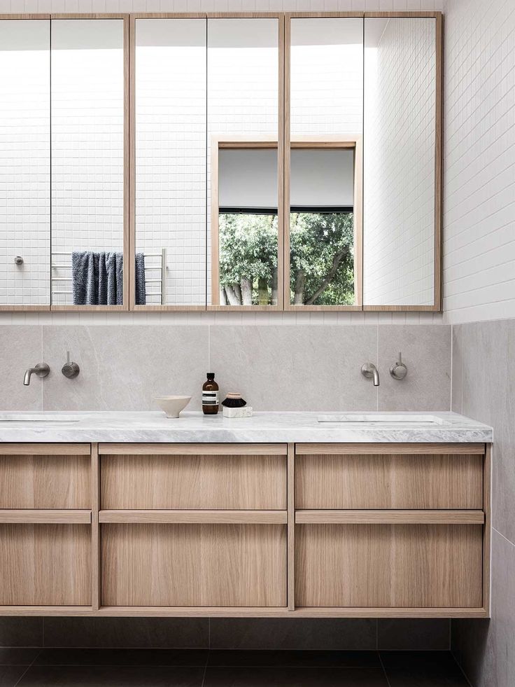 a bathroom with two sinks and mirrors in it