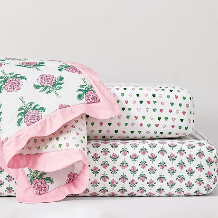 three sheets stacked on top of each other with pink and green hearts in the background