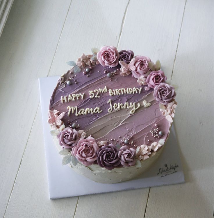 a birthday cake with purple frosting and flowers