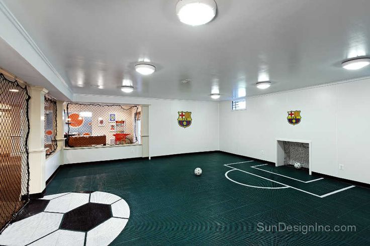 an indoor basketball court with soccer balls on the floor and other sports equipment in the room