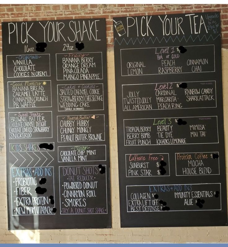 two blackboards with chalk writing on them in front of a brick wall that says pick your shake and pick your tea