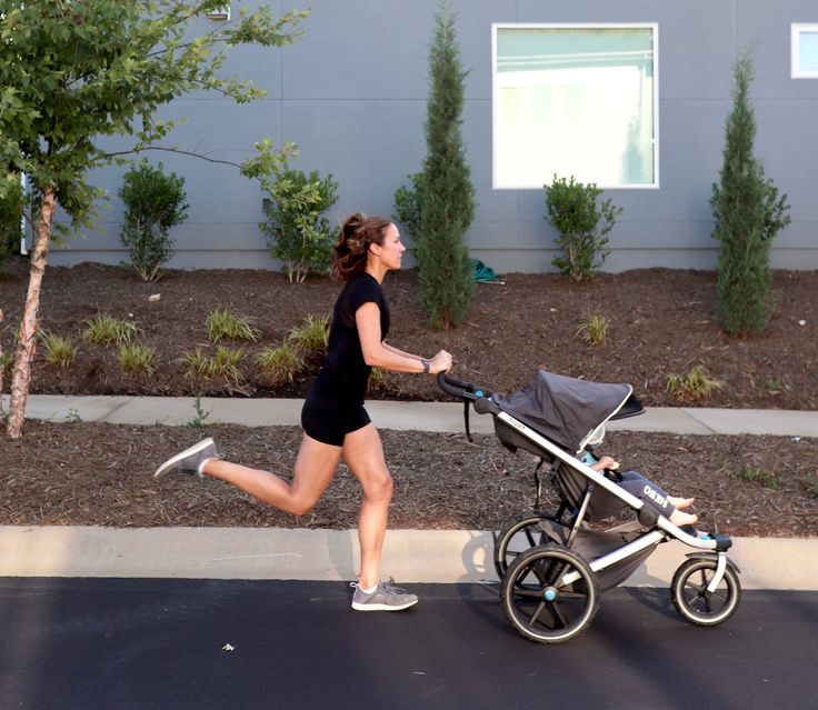 a woman jogging with her baby in a stroller