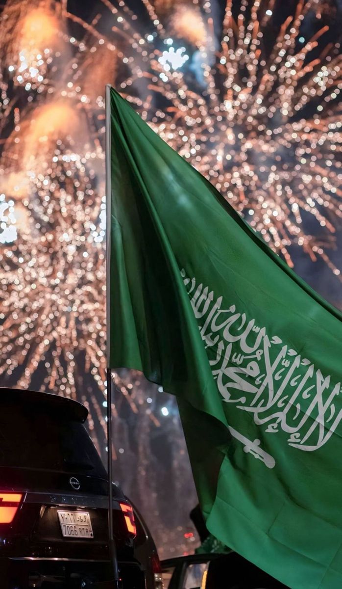 a green flag flying in front of fireworks