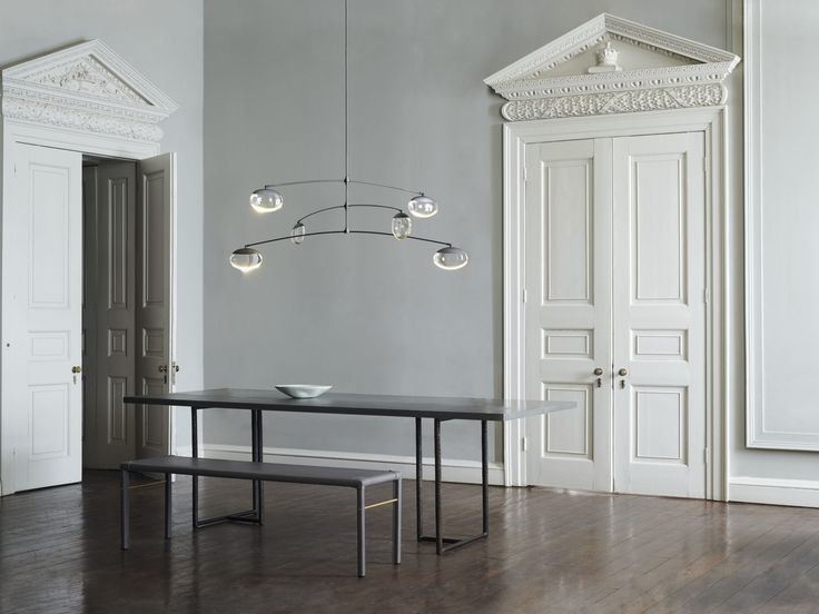 an empty room with a black table and two benches in front of the doorways