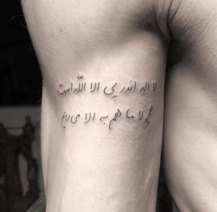 a man's leg with arabic writing on it and the words written in two different languages