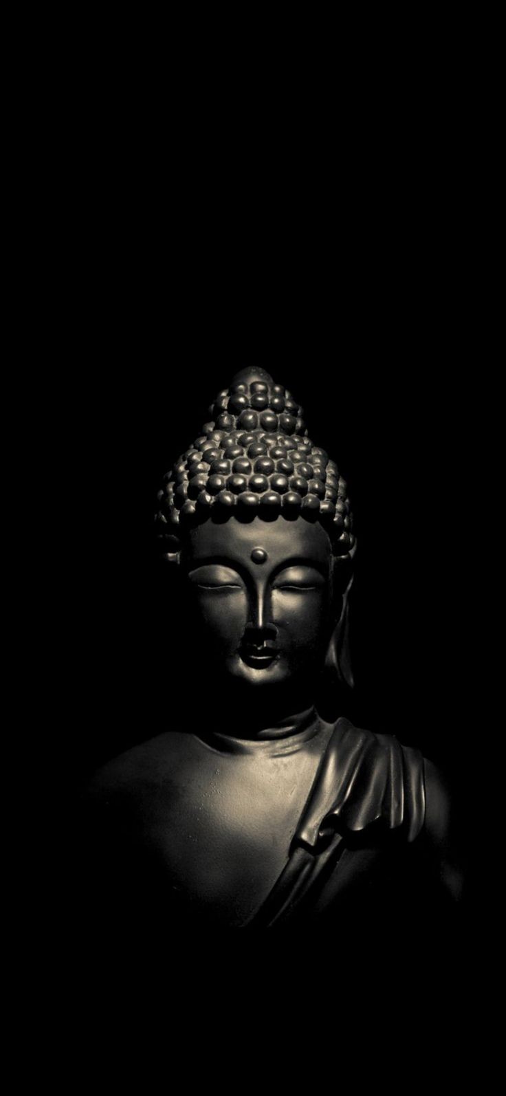 a black and white photo of a buddha statue with its eyes closed in the dark