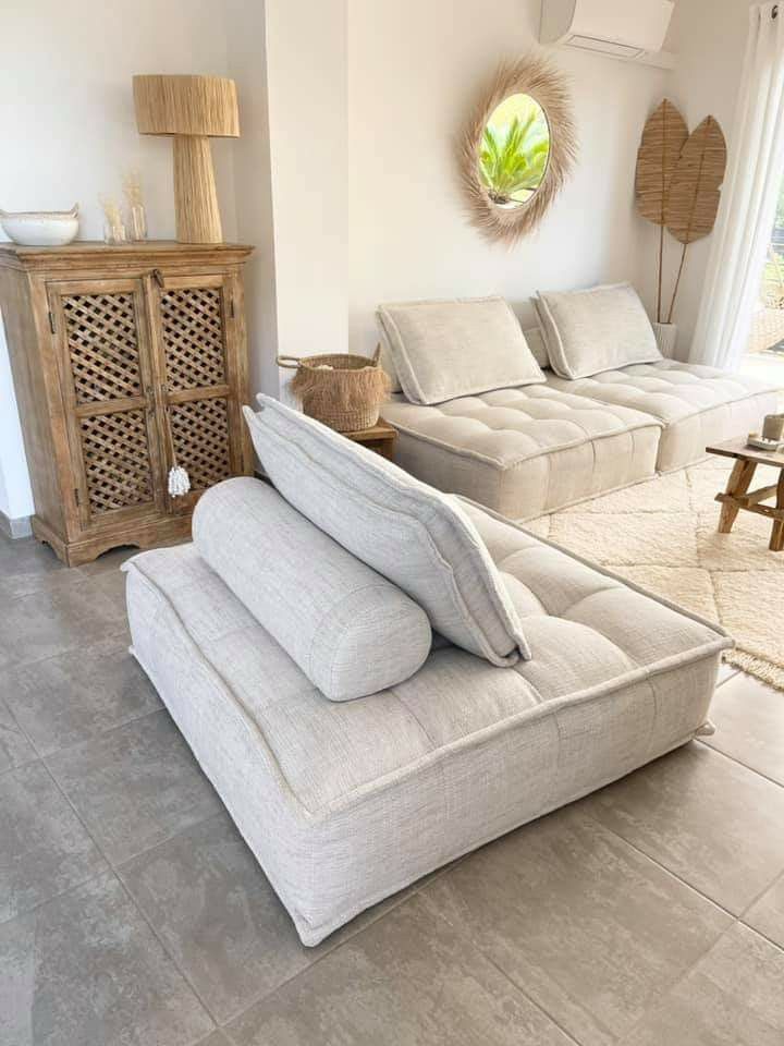 a living room with two couches and a table in front of a window that looks out onto the ocean