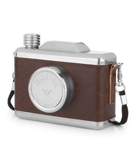 a brown and silver camera sitting on top of a white surface