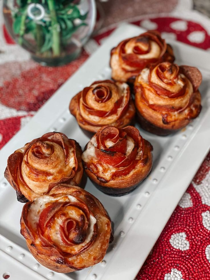 there are many small pastries on the white platter with red and white table cloth