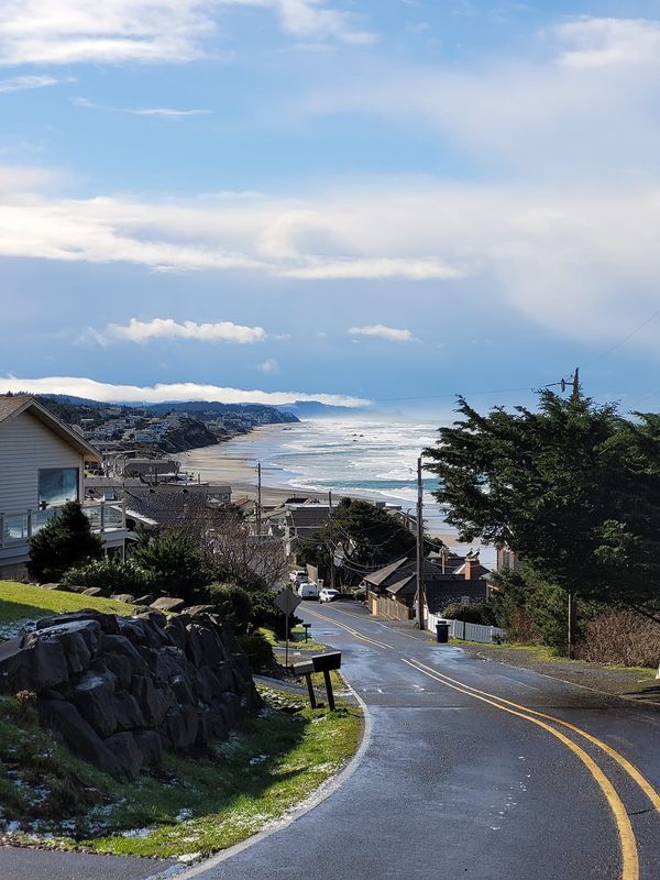 an empty street next to the ocean on a sunny day