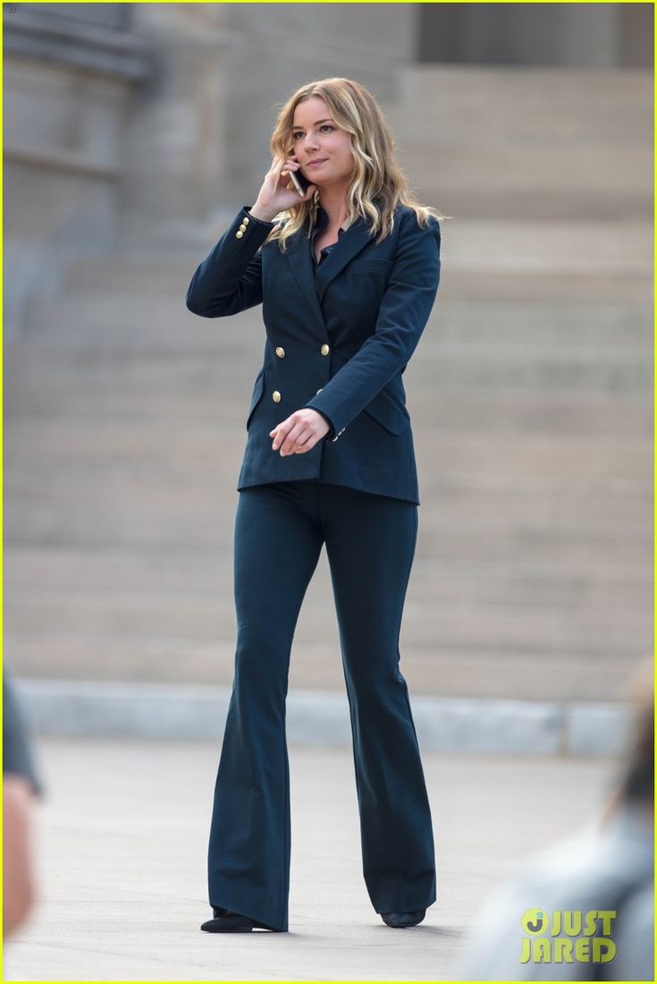 a woman talking on her cell phone while standing in front of some stairs and steps