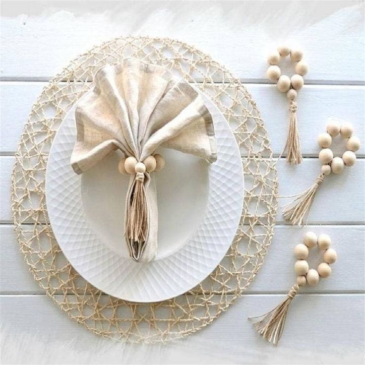 a white plate topped with a tasseled napkin next to other plates and decorations