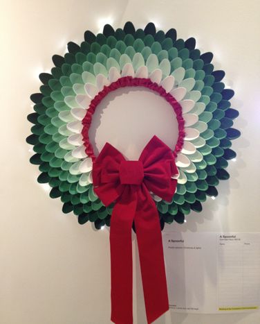 a paper wreath with a red bow hanging from it's side on a wall