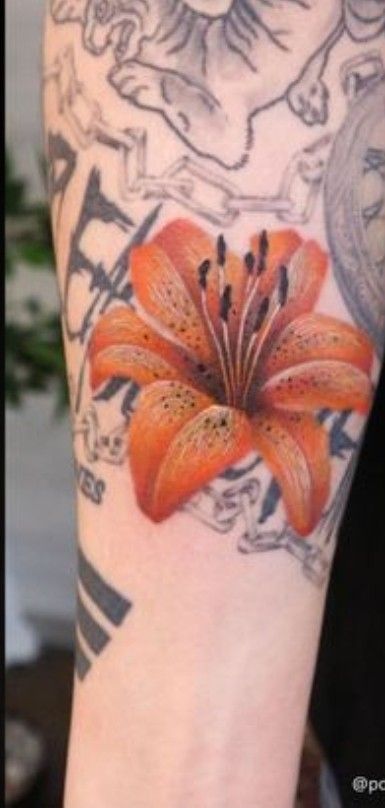 an orange lily tattoo on the arm