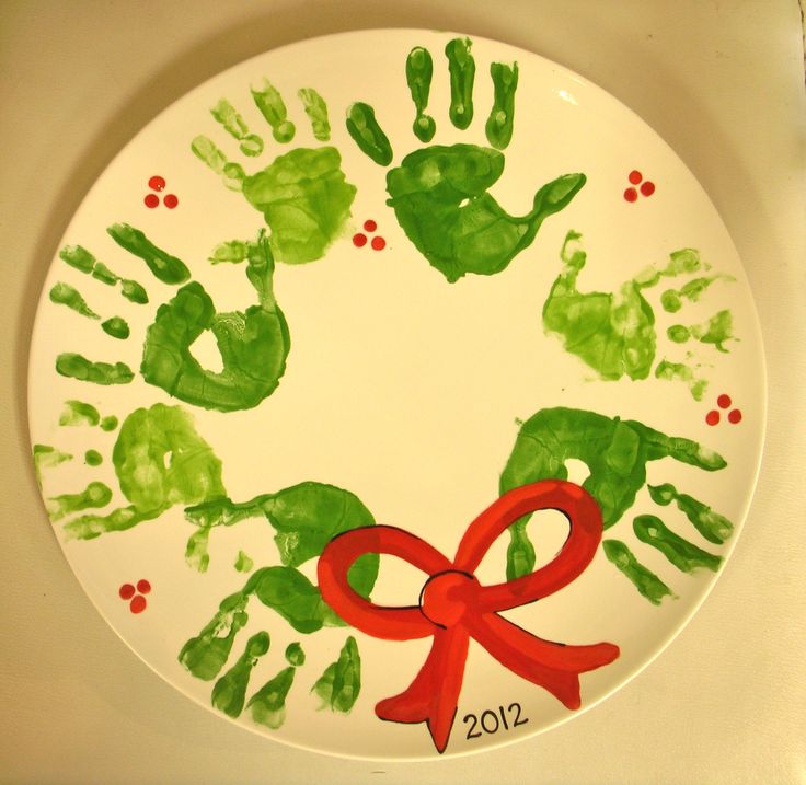 a plate decorated with handprints and a red ribbon