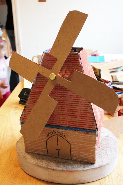 a cardboard windmill sitting on top of a wooden table