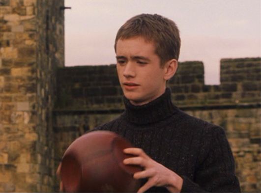 a young man holding a football in his right hand