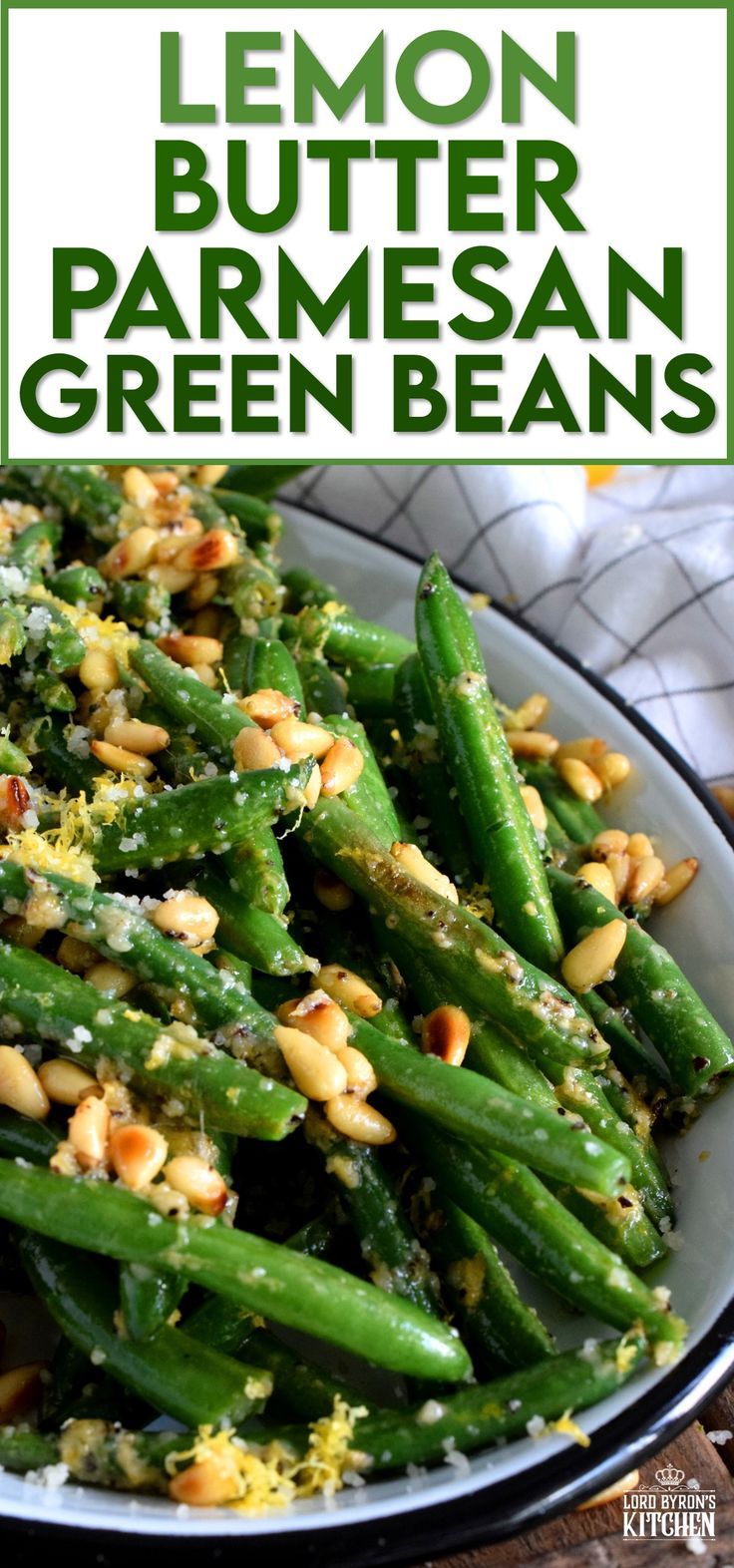 lemon butter parmesan green beans in a white bowl with pine nuts on top