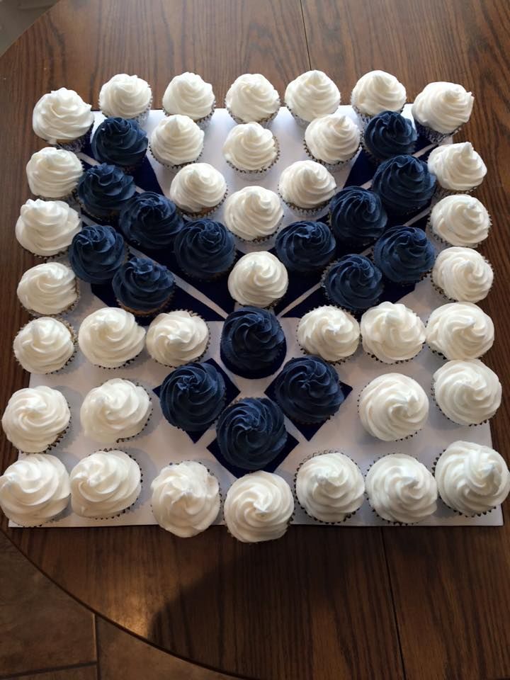 a cake with white frosting and blue icing roses on the top is sitting on a table