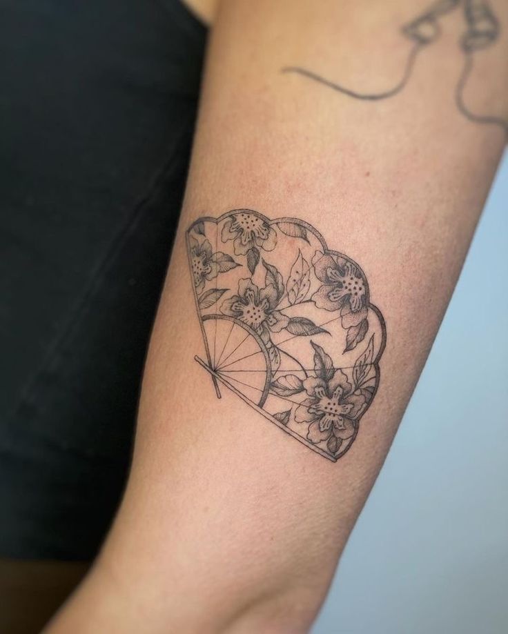 a woman's arm with a tattoo on it and an umbrella in the shape of a heart