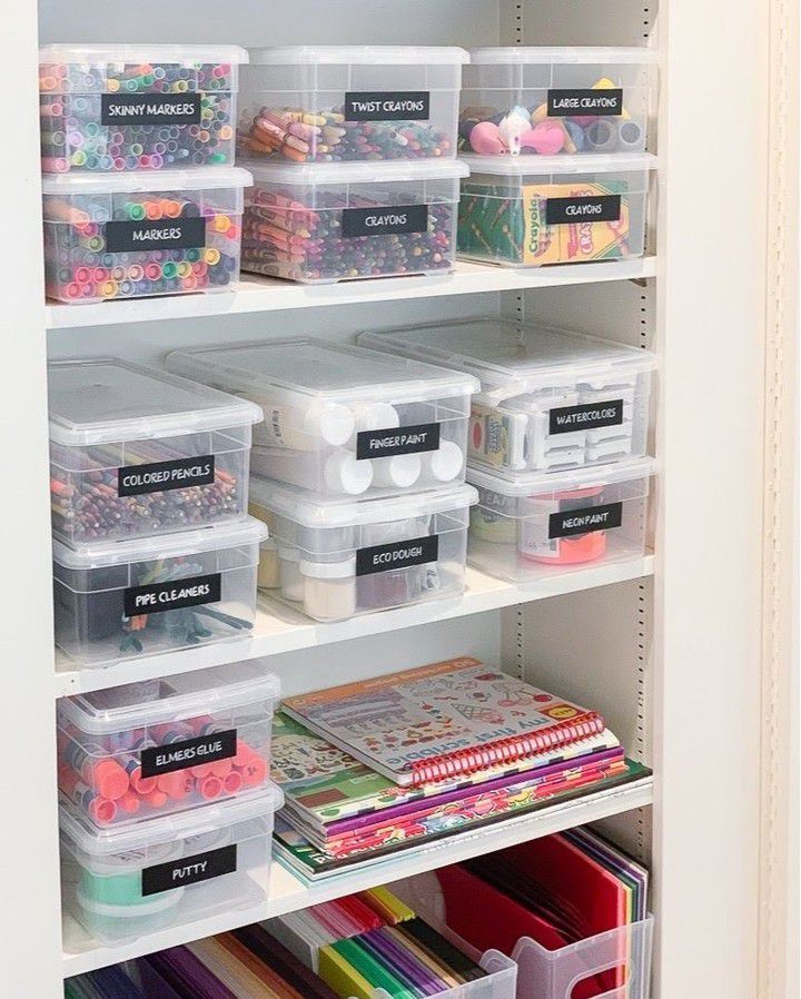 an organized closet with plastic bins and craft supplies