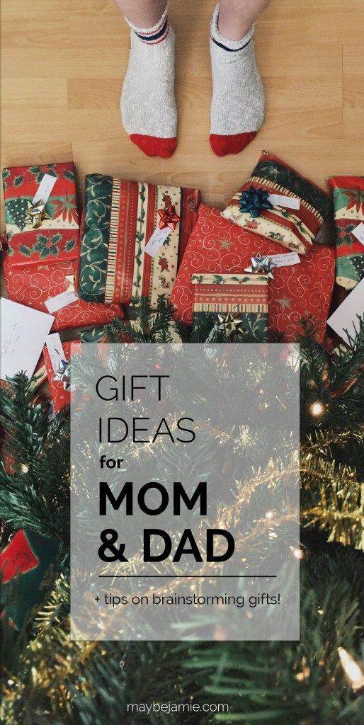 a person standing on top of a pile of presents under a christmas tree with the words gift ideas for mom and dad