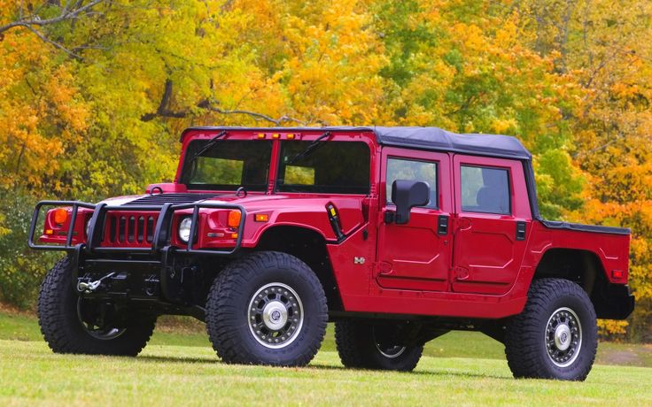 a red hummer truck parked in the grass