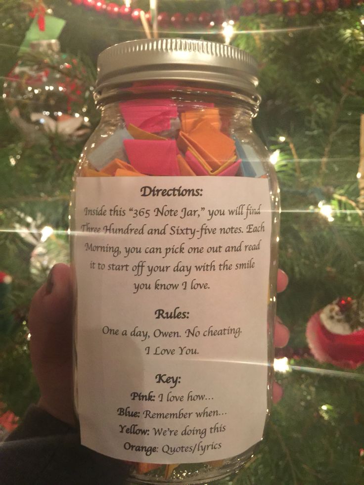 a jar filled with lots of different types of cookies on top of a christmas tree