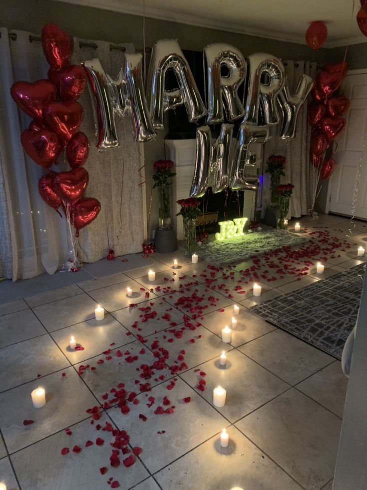 a room with candles and balloons on the floor