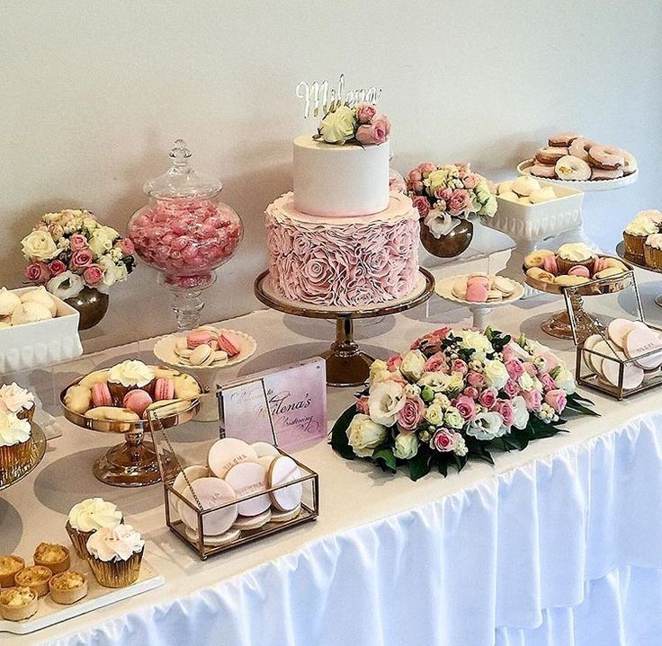 a table topped with lots of cakes and cupcakes