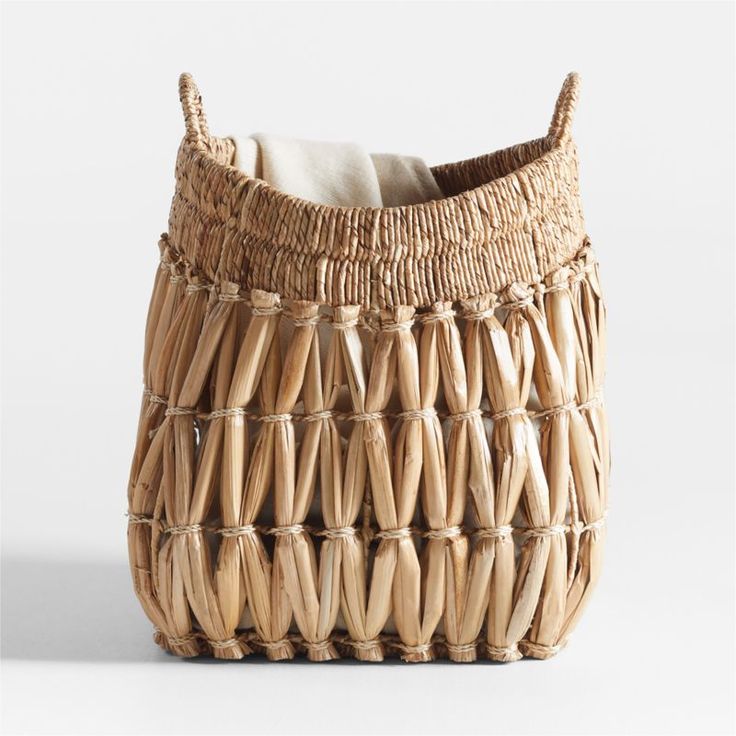 a woven basket with white linen in it