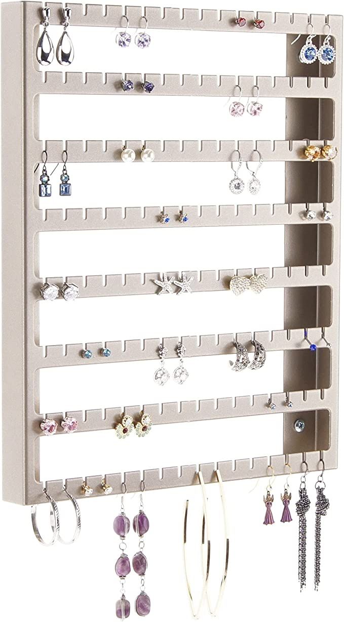 a wall mounted jewelry rack with several pairs of earrings