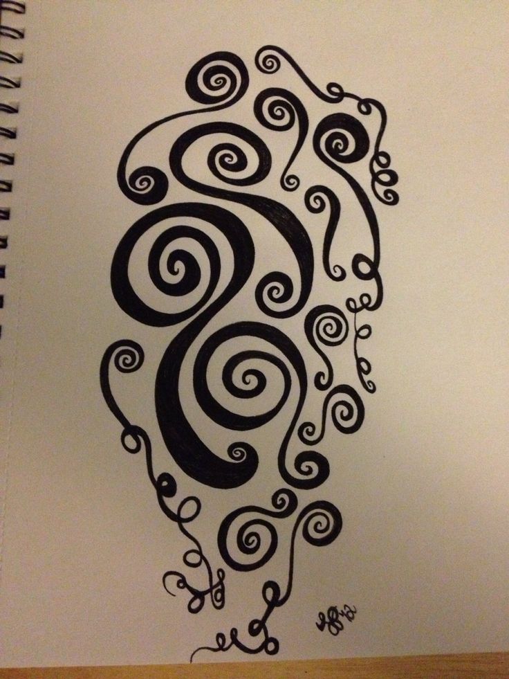 a spirally patterned design is drawn in black ink on a white paper with a wooden table