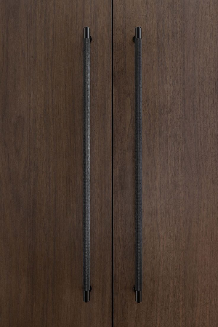 two wooden doors with black handles on them