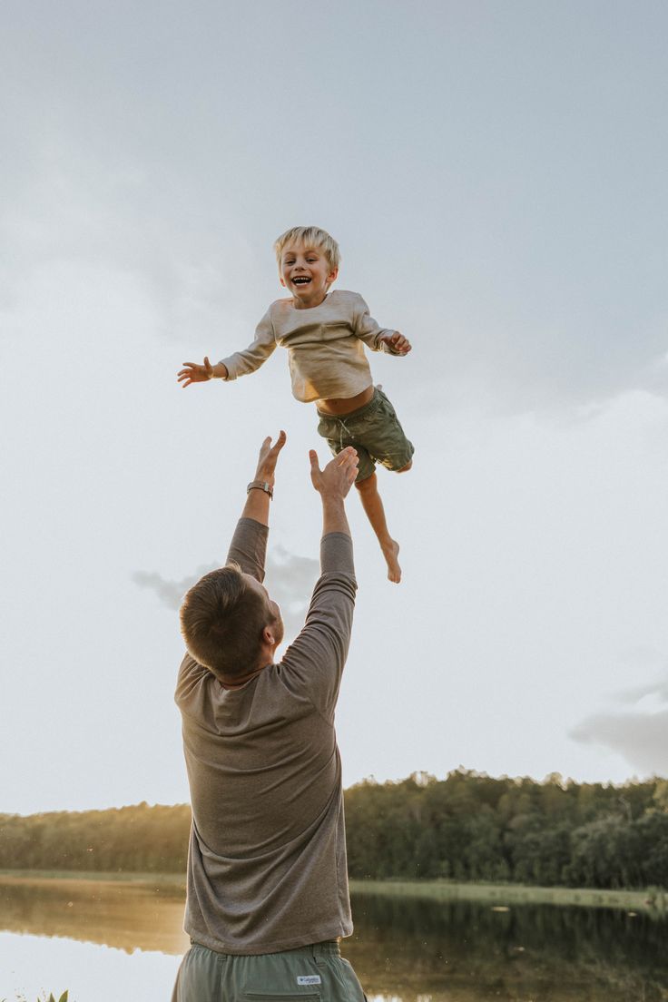 a man holding up a child in the air