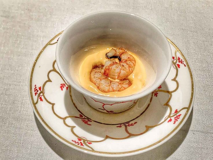 a white bowl filled with soup on top of a saucer