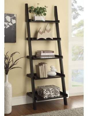 a leaning shelf with books on it in front of a beige wall and white rug