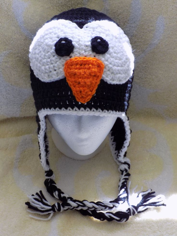 a crocheted penguin hat on top of a mannequin's head